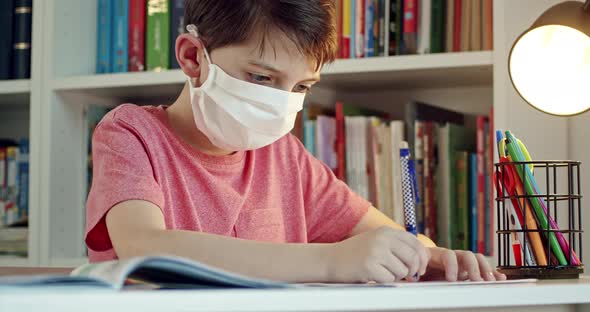 Student Wearing Surgical Protective Mask Working on School Assignments