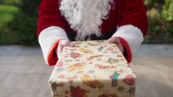 POV Santa Clause Giving Present to Unrecognizable Person Standing on Backyard Porch alt
