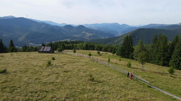 Two girls going on the mountains lane to the hut