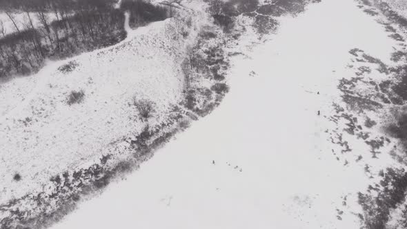 Fisherman is drilling ice on frozen lake at winter fishing alt