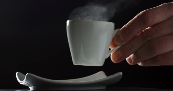 Putting a cup of hot coffee on a plate alt