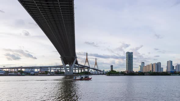 Large suspension bridge over Chao Phraya river at twilight, day to night, zoom in - time lapse