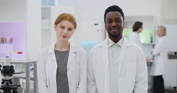 Portrait of Multiethnic Young Scientists Smiling at Camera in Modern Laboratory alt