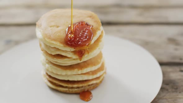 Video of pancakes with maple syrup on white plate seeing from above alt