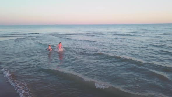 Young Sister and Brother Who Are Playing in the Sea