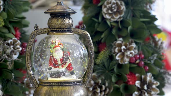 Beautiful snowglobe with Santa Clauss on Christmas background. Flat plane alt