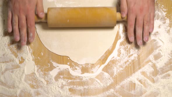 Top View of Cook Rolling Dough with Rolling Pin