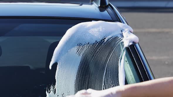 Washing car with sponge and shampoo