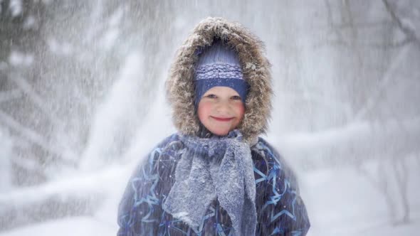 Portrait of a Beautiful Blonde Little Boy in the Winter Forest with Falling Snow - Slow Motion Video