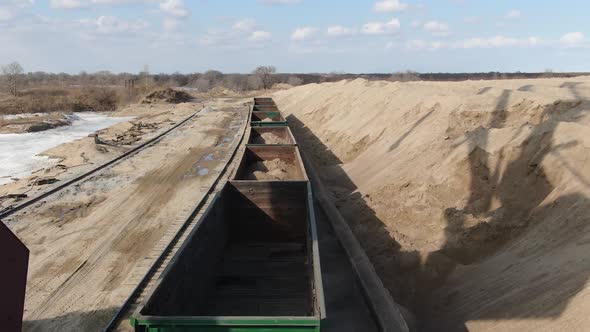 Loading Sand Into Rail Cars with the Help of a Career Excavator