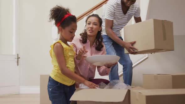 African American couple and their daughter moving into new house alt