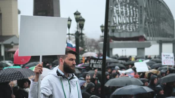 Bearded Man on Rally Holding Blank Ads Board