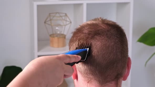 A Man Cuts His Hair with Clipper