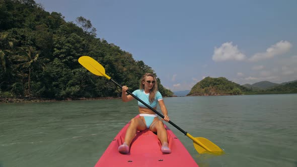 Sportive Woman Rows Pink Plastic Canoe Along Sea Water