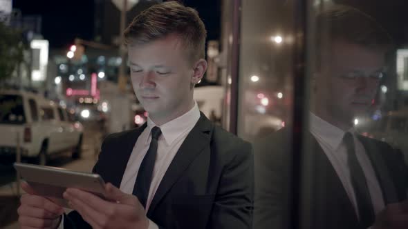 Young Businessman Looking at Tablet Screen alt
