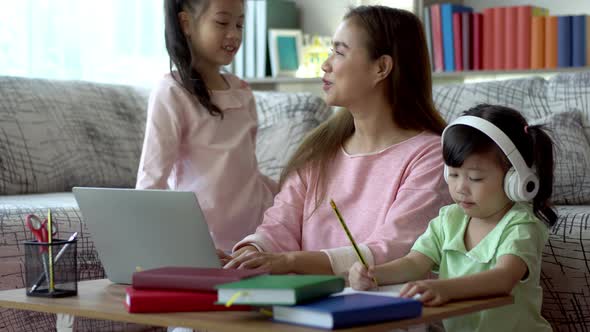 An Asian mother Working From Home With Her Children 02 alt