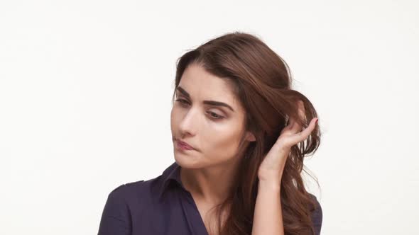 Thoughtful Attractive Young Caucasian Female in Dark Blue Shirt with Long Brown Hairstanding on alt