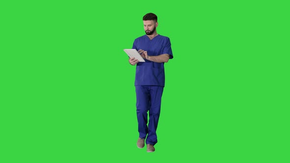 Confident Concentrated Focused Surgeon Using Digital Tablet on a Green Screen, Chroma Key. alt