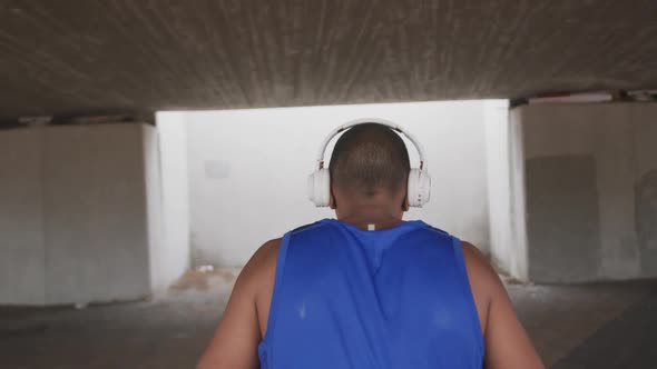 Rear view man with prosthetic leg listening to music alt