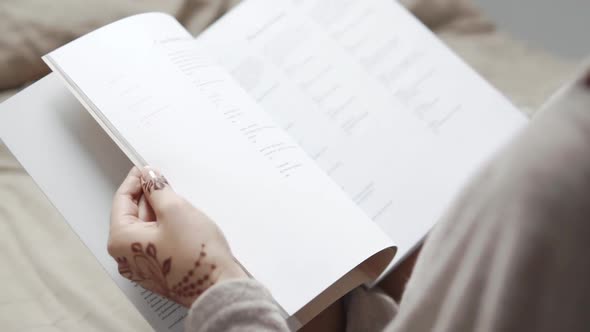 Girl Is Flipping Pages of Book, View From Her Shoulder, Close-up alt