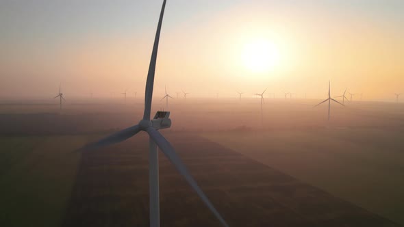 Close-up of wind turbine blades at sunset or sunrise. Windmills with rotating wings