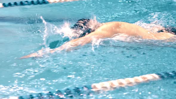 Medium Close Up Torso of Athletic Young Swimmer Performing Crawl Style in Swimming Pool alt
