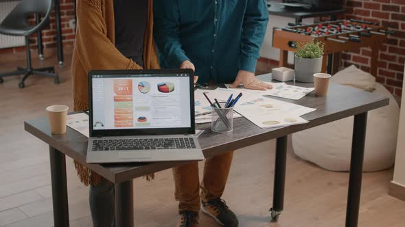 Close Up of Laptop and Papers with Data Rate Charts on Table alt