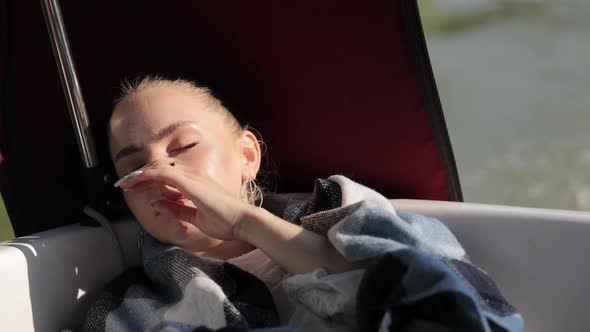 A Young Girl is Sleeping and Scratching Her Nose alt