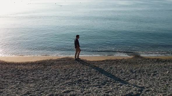 Aerial Shot of Young Man Walking on Beach and Relaxing