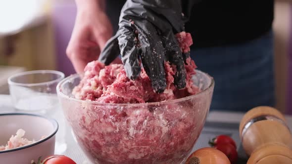 Kneading of Minced Meat with Onion and Spices in a Glass Bowl alt