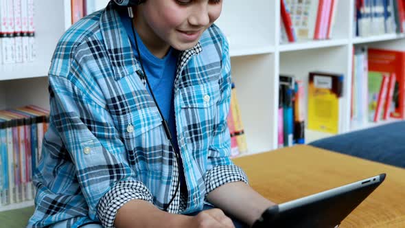 Student using digital tablet in library alt