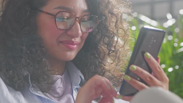 Close Up of Woman Using Modern Smart Phone at Home Sitting on the Sofa Enjoying Internet Connection alt