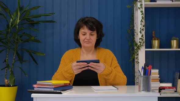 Middle Aged Woman Play Mobile Game Whit Mobile Phone at Home