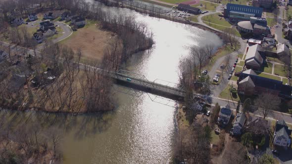 Aerial Drone Shot Tilting Up Over Lake With Bridge in Suburban New Jersey