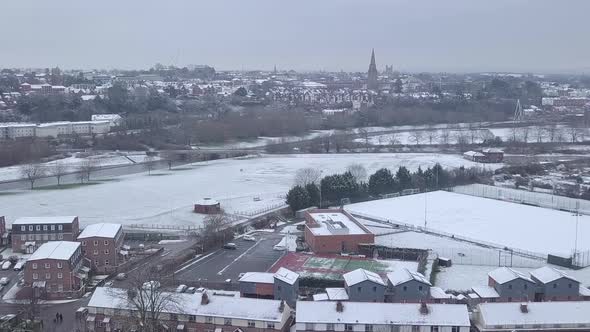 Push forward drone shot of a snowy Exeter looking towards the town centre over the River Exe alt