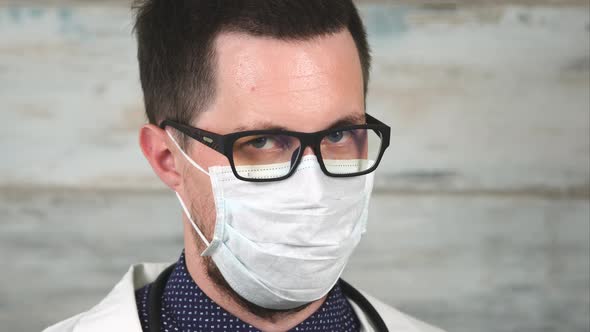 Doctor with a Strict Look. Portrait of a Man in Glasses and Medical Mask alt