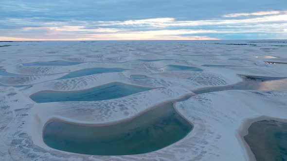 Drone Going Backwards, In A Bluish End Of Day, Blue Lagoons, White Sand, Colorful Clouds