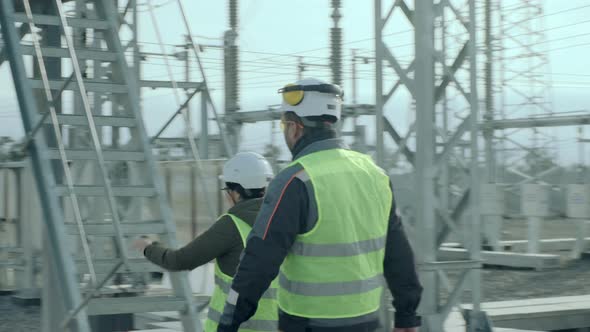 Electrical Engineers Climb Industrial Power Station Ground