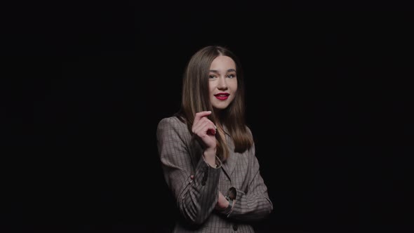 A stylish young brunette in a jacket feels happy, smiling cheerfully and posiпg