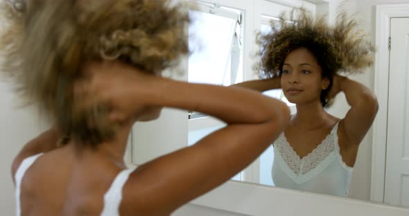 Reflection of smiling woman looking in the mirror alt
