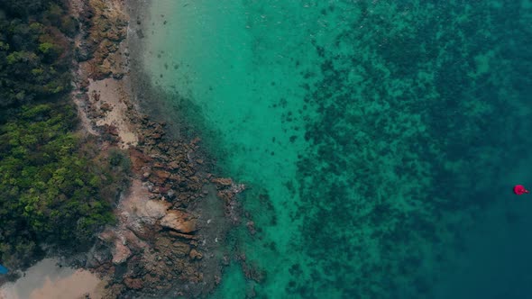 Red Buoy Floats Against Narrow Sand and Rock Empty Coastline alt