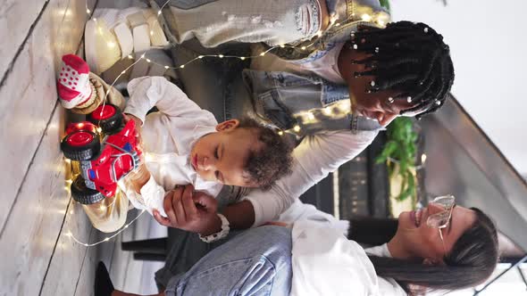 Multiracial Modern Family Sitting on the Floor Enjoying Christmas Eve alt