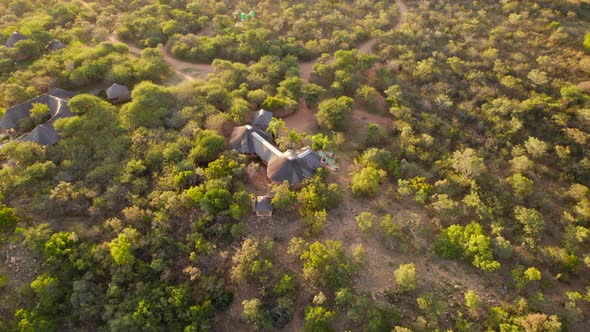 Aerial drone rotation of African luxurious lodge in middle of green savannah bush. South African acc alt