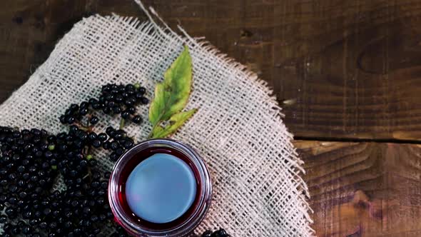 Ripe Black Berry Top View. Natural Elderberry Juice In A Glass Jar On Wooden Boards.Homeopathy