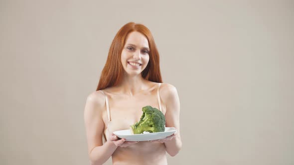 Joyful Skinny Girl Keeps Broccoli in a Plate, Afraid of Excess Weight, Anorexia alt