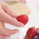 Strawberries are Cut Into Pieces on a Wooden Cutting Board to Decorate Desserts 