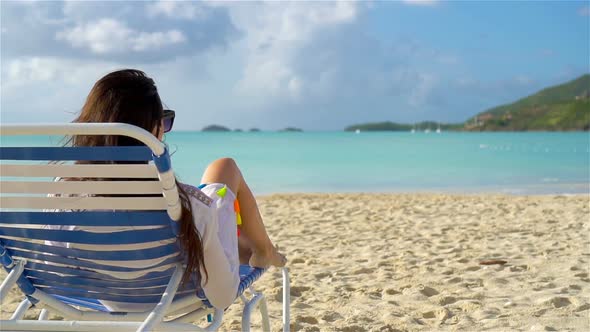 Woman Sunbathing on a Lounger at Tropical White Beach alt