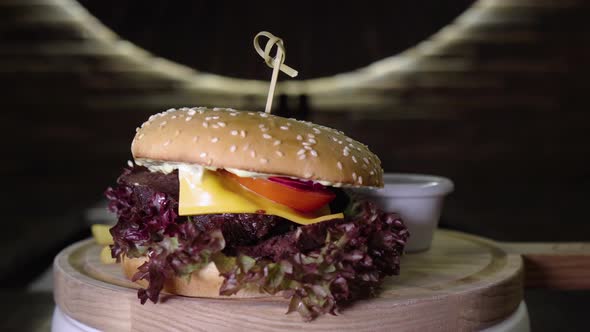 Appetizing Beef Burger Rotating on the Wooden Desk