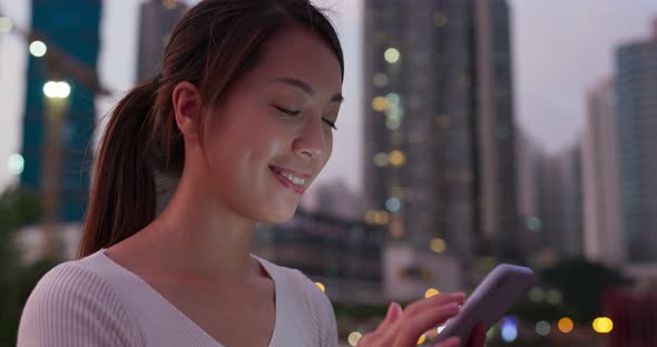 Woman use of mobile phone in city at night alt