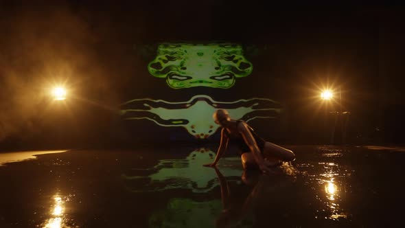 Artistic Young Woman Performing Against Dark Animated Background in Studio alt